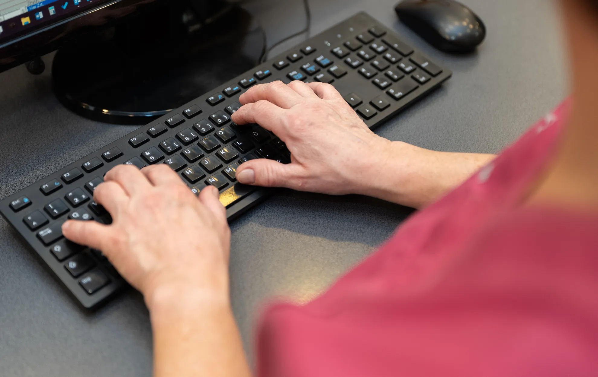Nahaufnahme von Händen die auf der Tastatur tippen